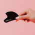 Hand holding a black Gua Sha tool with &