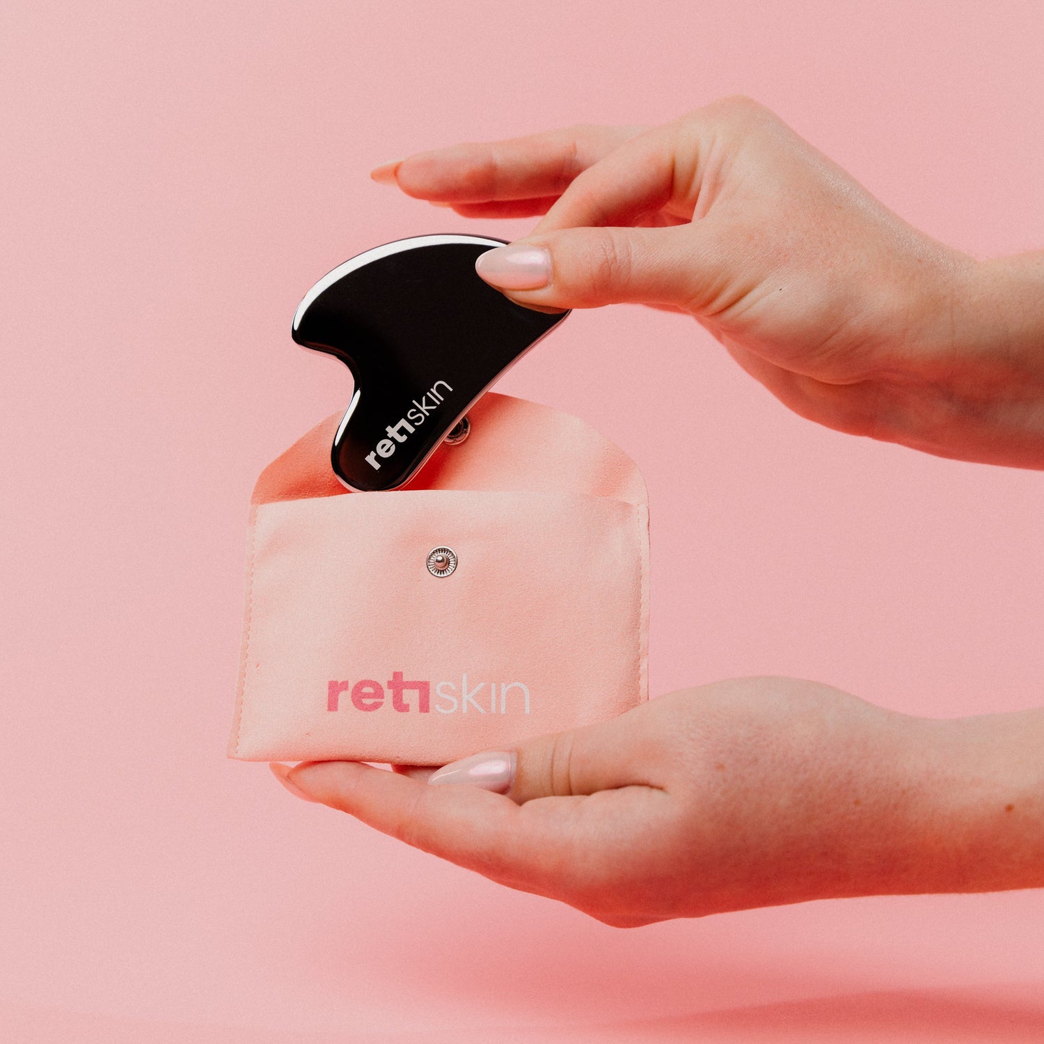 Hand holding a pink device with 'retskin' branding against a pink background