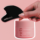 Hand holding a black skincare tool with a pink container labeled &